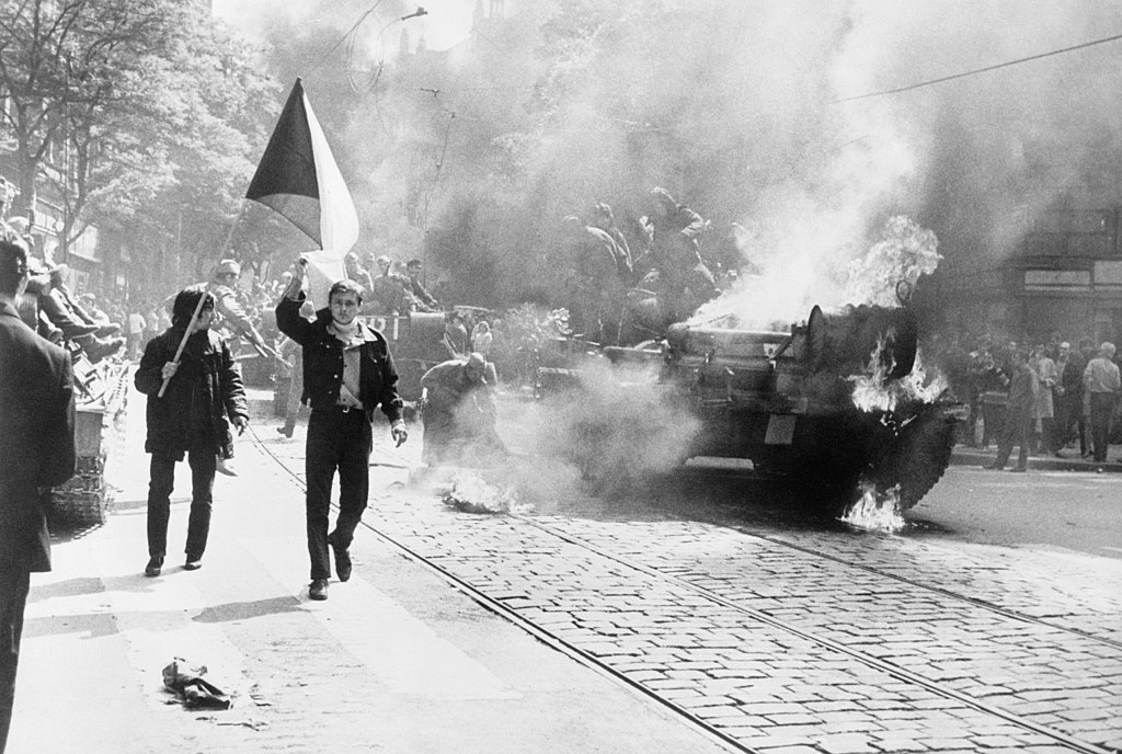 During the Soviet invasion of Czechoslovakia Czechoslovaks carry their national flag past a burning tank in Prague photo from CIA Analysis of the Warsaw Pact Forces