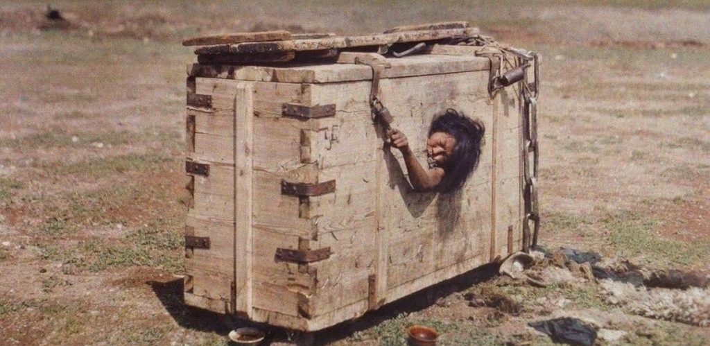 A Mongolian woman reaches out from the porthole of a crate in which she is imprisoned by Stephane Passet