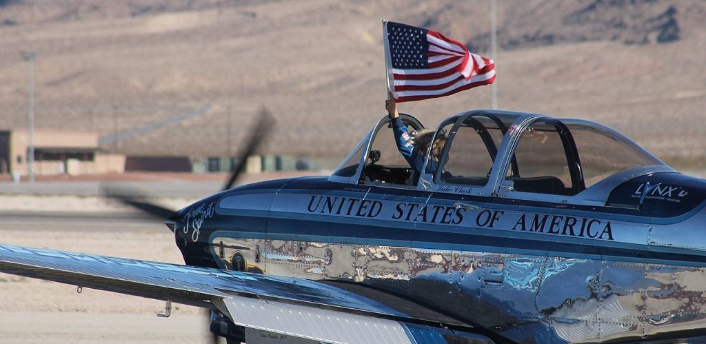 Julie Clark taxiing Free Spirit while waving the American flag by Noah Wulf