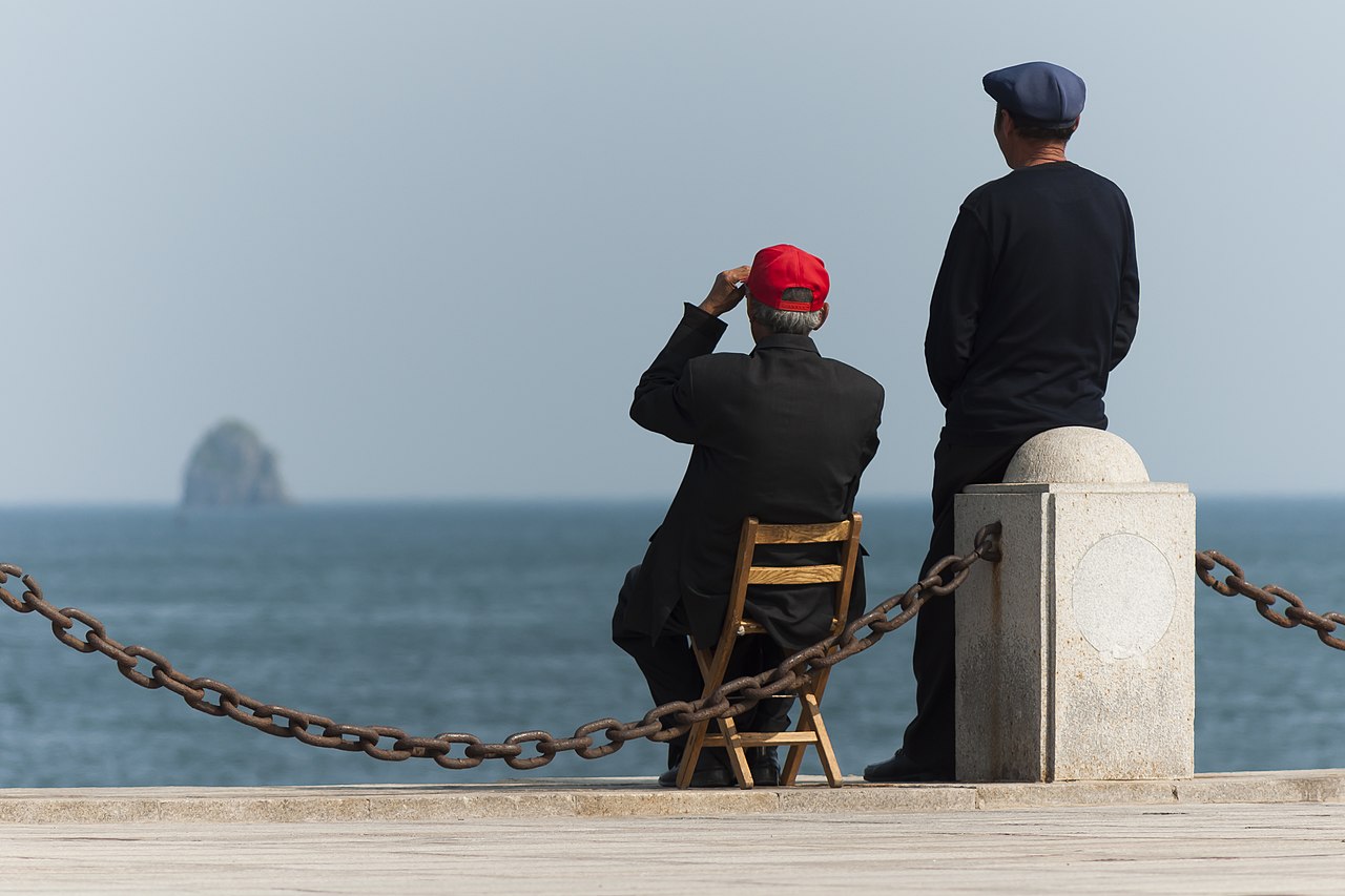 Dalian Liaoning China. Two elderly Chinese guys enjoying the sea at Xinghai Bay by Uwe Aranas