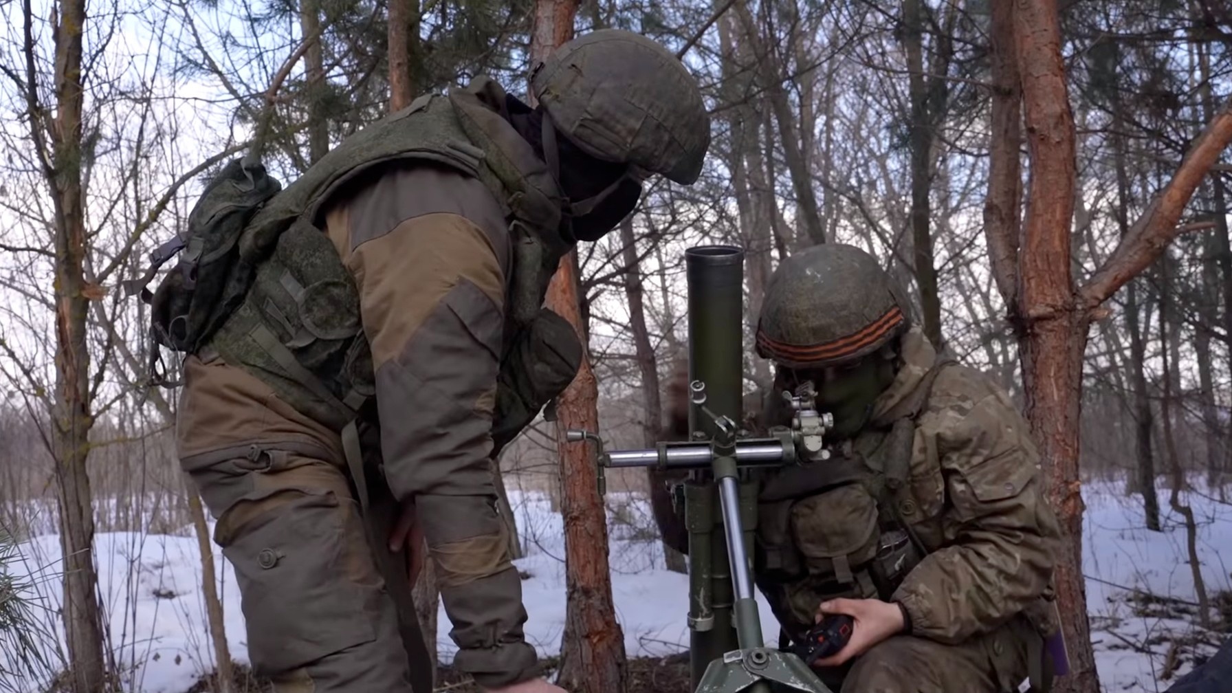 Ruští vojáci v hnědých maskáčích si na pozadí zasněžených stromů prohlížejí vojenské vybavení, Ministerstvo obrany RF
