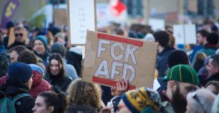 a crowd of people holding up signs and placards